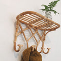 Crisscross woven rattan wall coat rack with four hooks and a top shelf