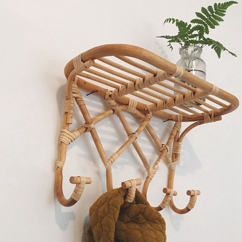 Crisscross woven rattan wall coat rack with four hooks and a top shelf