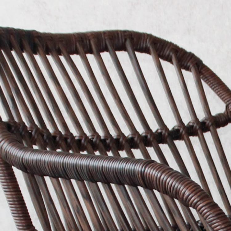 Rocking chair hand woven in deep brown rattan with a dense regular weave