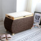 Chocolate brown woven storage stool with a padded floral lid on light wood feet