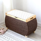 Chocolate brown woven storage stool with a padded floral lid on light wood feet