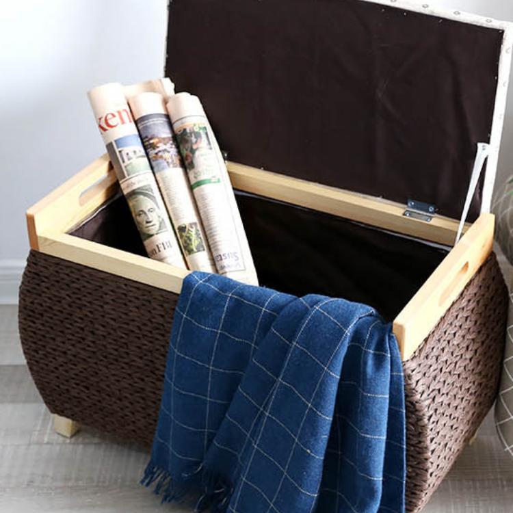 Chocolate brown woven storage stool with a padded floral lid on light wood feet