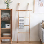 Tall decorative bamboo blanket ladder leaning against a wall