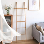 Tall decorative bamboo blanket ladder leaning against a wall