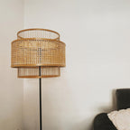 Sculptural floor lamp with two round hand woven rattan shades stacked on a bamboo frame
