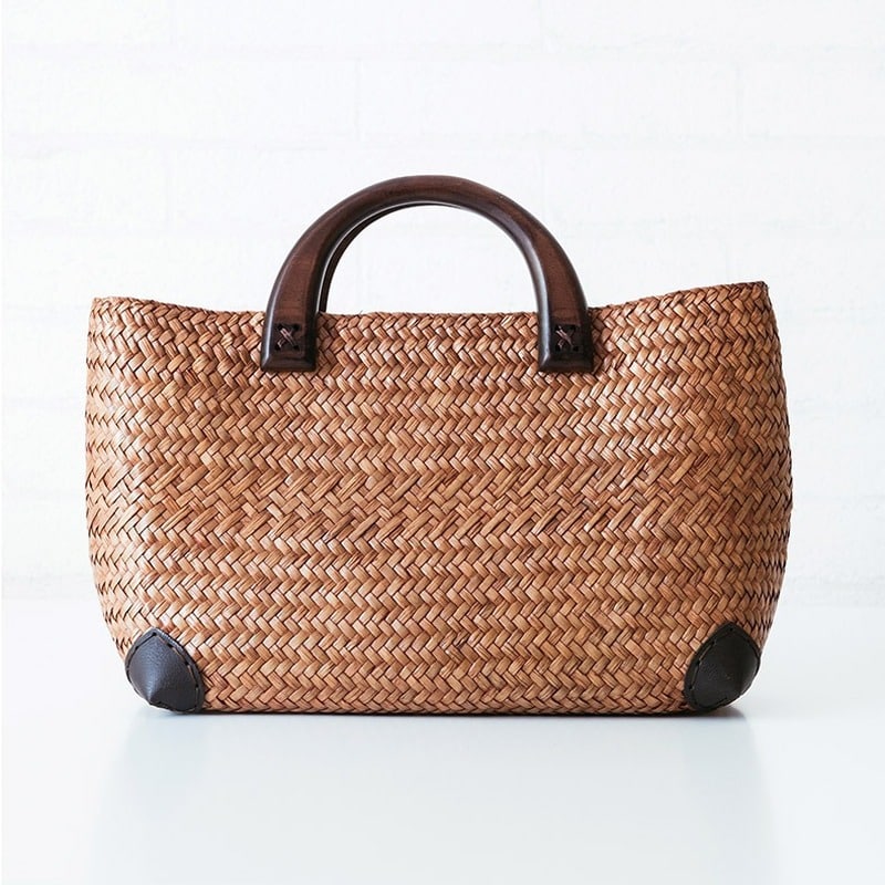 Hand woven rattan bag with polished wooden handles