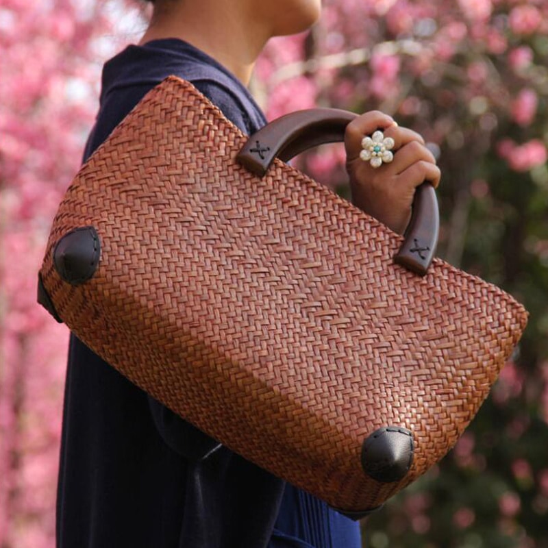 Hand woven rattan bag with polished wooden handles