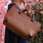 Hand woven rattan bag with polished wooden handles
