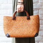 Hand woven rattan bag with polished wooden handles