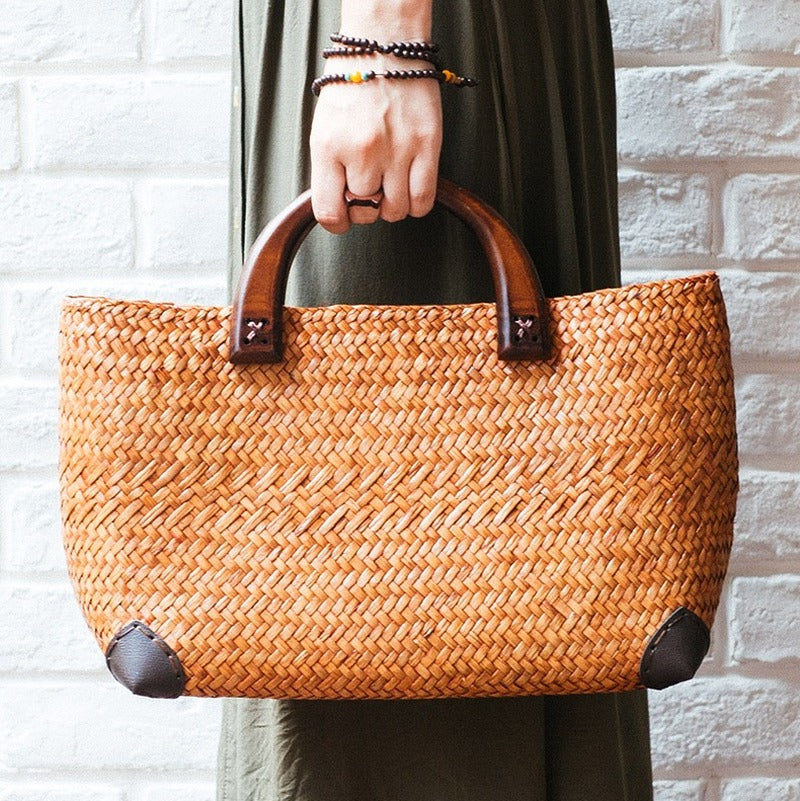 Hand woven rattan bag with polished wooden handles