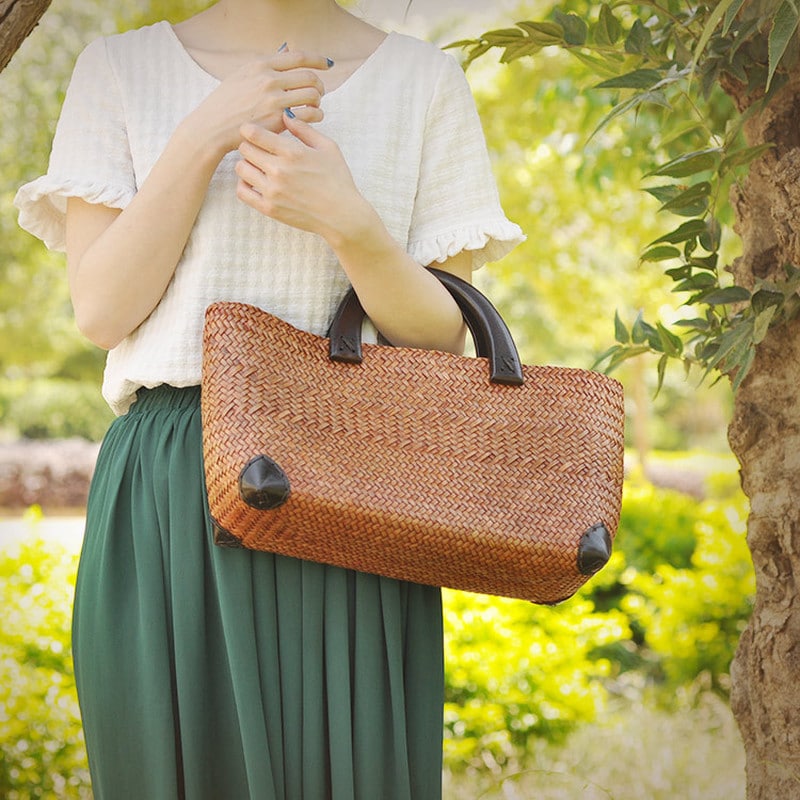 Hand woven rattan bag with polished wooden handles