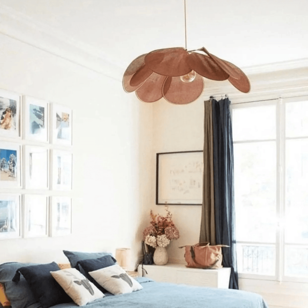 Large flower shaped fabric petal pendant light over a bed