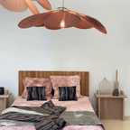 Large flower shaped fabric petal pendant light over a bed