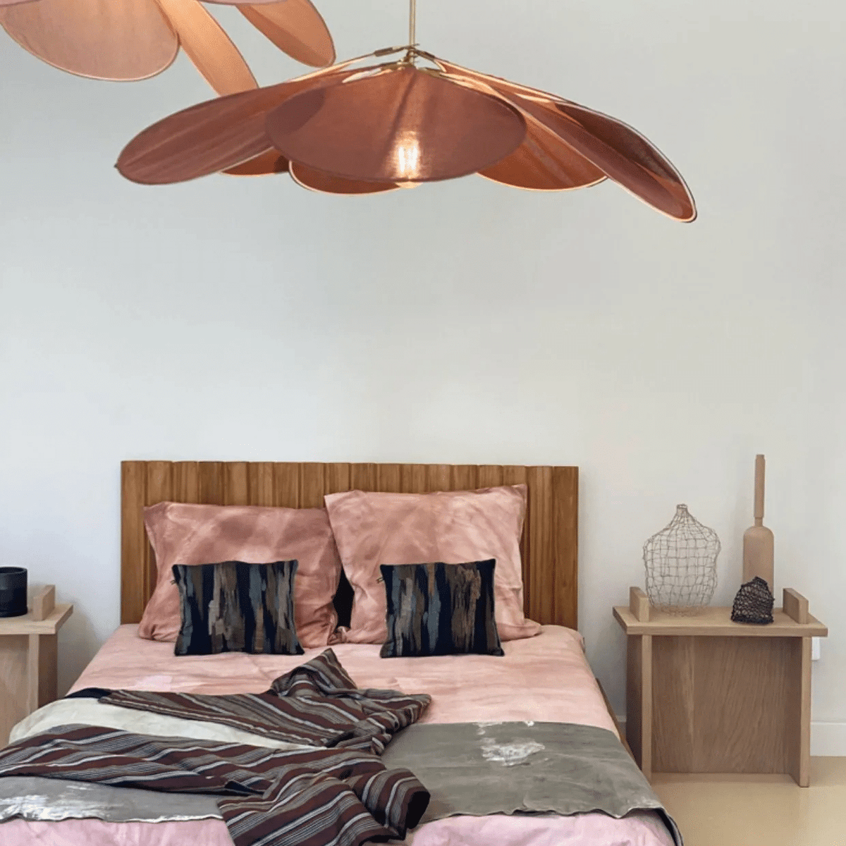 Large flower shaped fabric petal pendant light over a bed