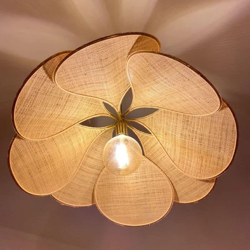 Large flower shaped fabric petal pendant light over a bed