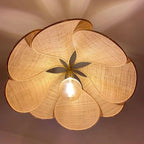 Large flower shaped fabric petal pendant light over a bed