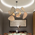 Sculptural chandelier of floating woven bamboo leaf panels over a dining table