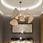 Sculptural chandelier of floating woven bamboo leaf panels over a dining table