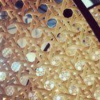 Sculptural chandelier of floating woven bamboo leaf panels over a dining table