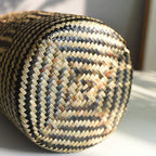Round hand woven rattan planter with black geometric diamond pattern
