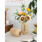 Glass vase in a woven rattan sleeve with a square pattern