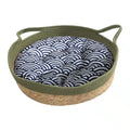 Round woven dog basket with green rim and patterned cushion