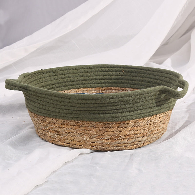 Round woven dog basket with green rim and patterned cushion