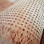 Roll of greenish rattan cane webbing with a round open mesh