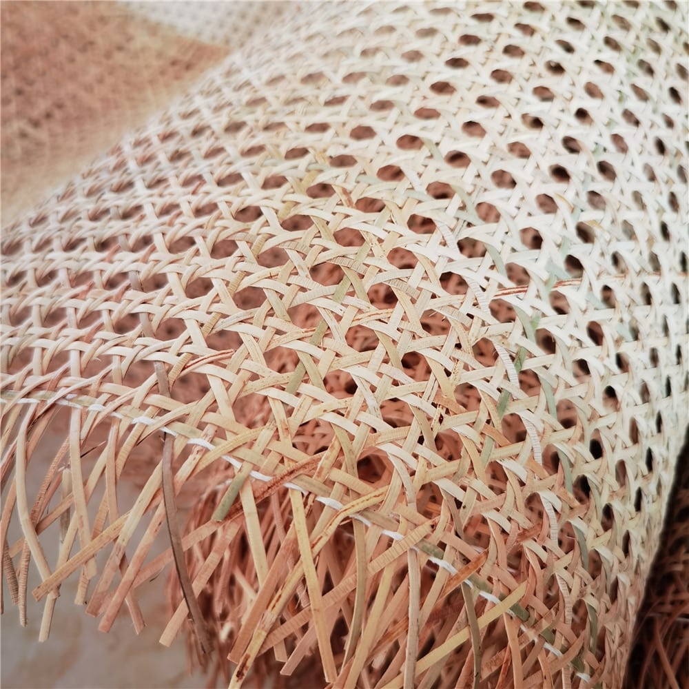 Roll of greenish rattan cane webbing with a round open mesh