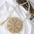 Small rounded hand woven straw crossbody bag in beige and caramel tones