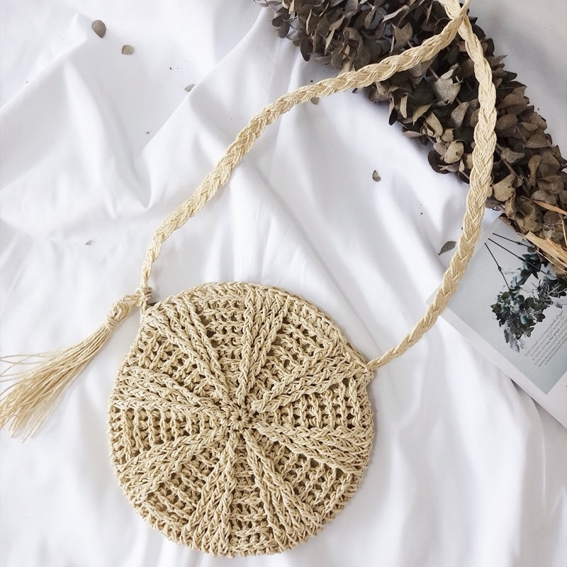 Small rounded hand woven straw crossbody bag in beige and caramel tones