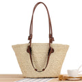 Beige hand woven straw tote with two tone brown handles and a crossbody strap