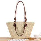 Beige hand woven straw tote with two tone brown handles and a crossbody strap