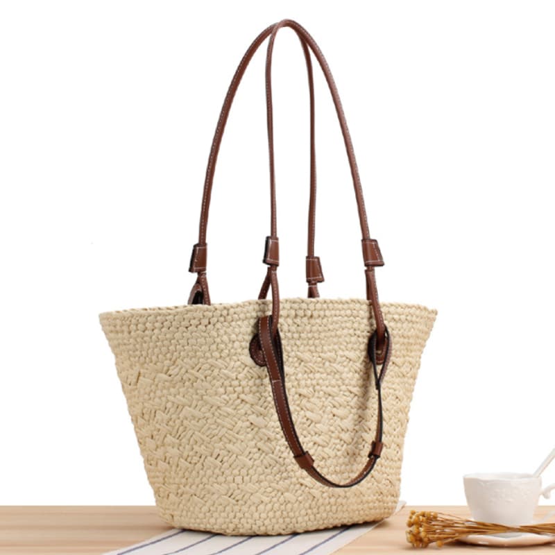 Beige hand woven straw tote with two tone brown handles and a crossbody strap