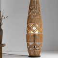 Tall lamp with a tightly hand woven brown wicker shade on a wood and iron stand