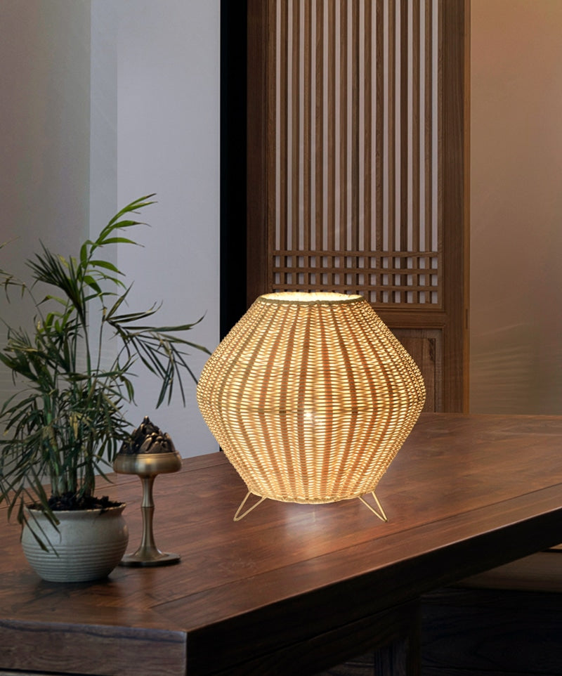 Handmade woven bamboo table lamp with a tapered silhouette and curved top