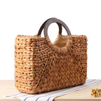 Structured hand woven rattan beach bag with a sturdy handle and outer pockets