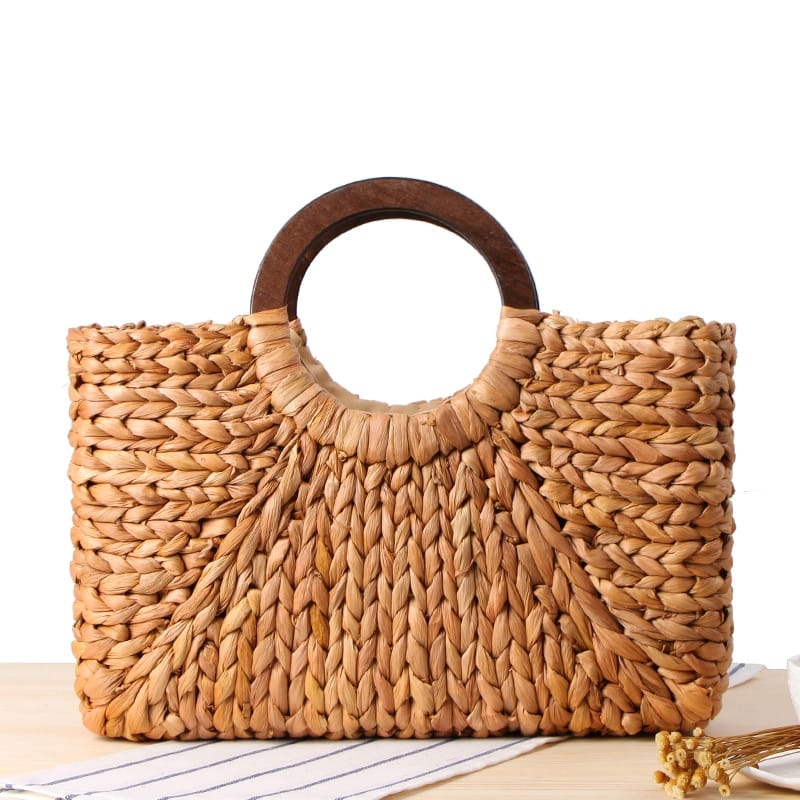 Structured hand woven rattan beach bag with a sturdy handle and outer pockets