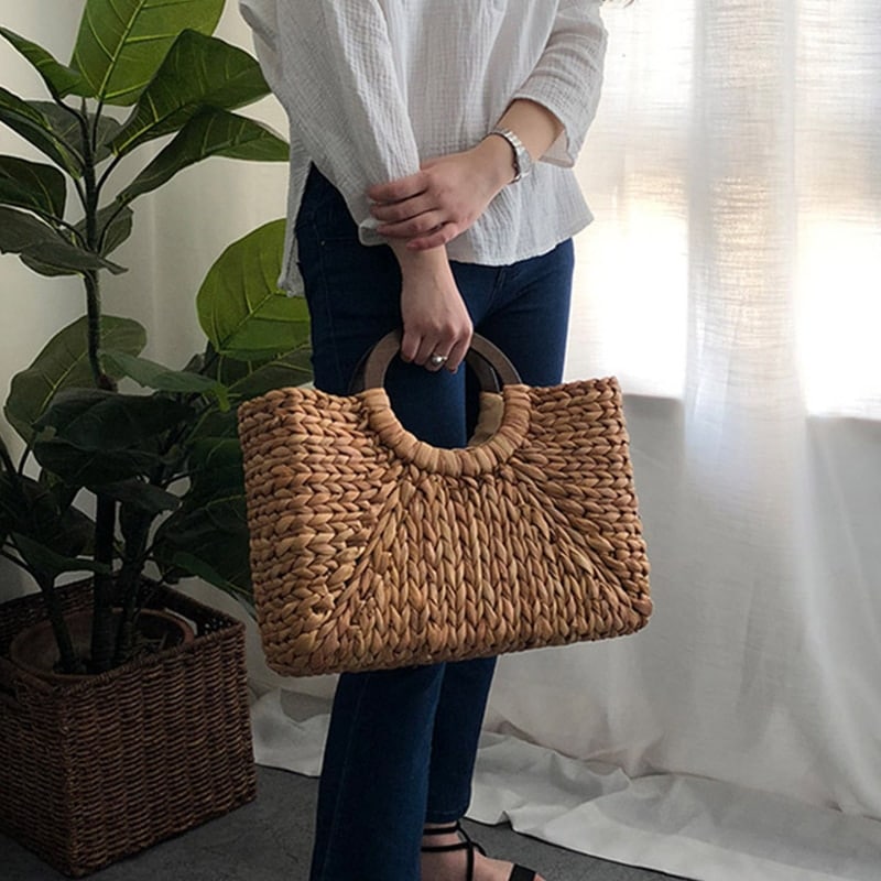 Structured hand woven rattan beach bag with a sturdy handle and outer pockets