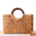 Structured hand woven rattan beach bag with a sturdy handle and outer pockets