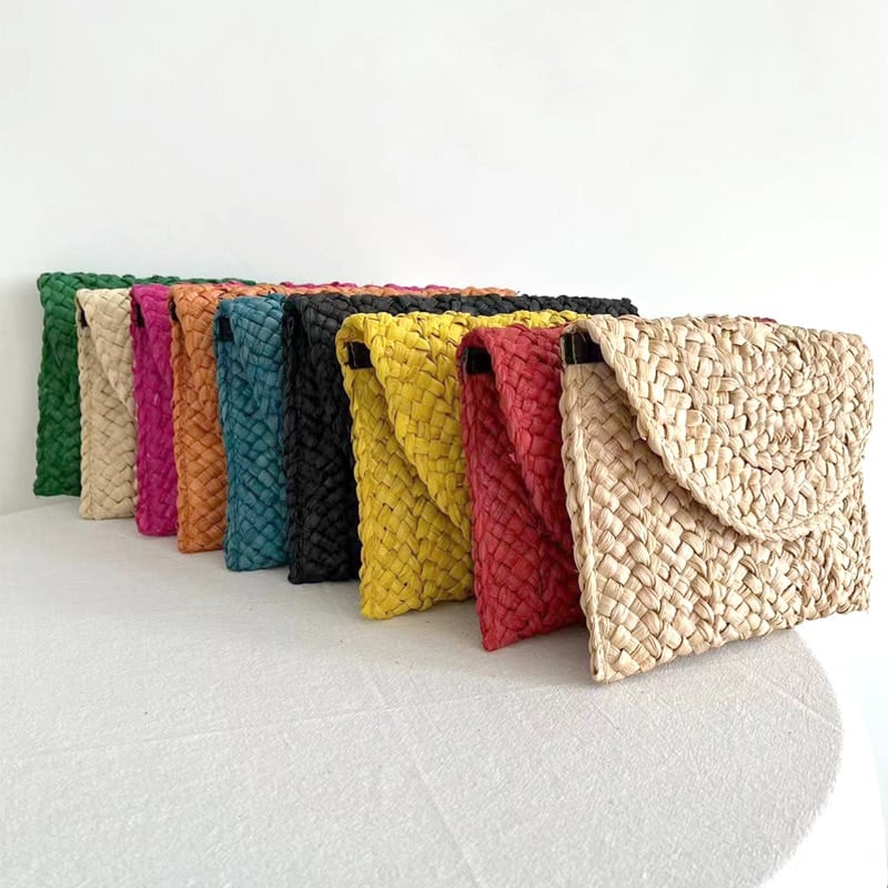 Small handmade woven straw clutch with a colorful pompom, offered in nine colors