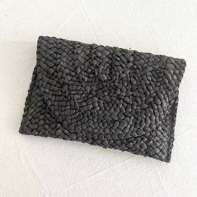 Small handmade woven straw clutch with a colorful pompom, offered in nine colors