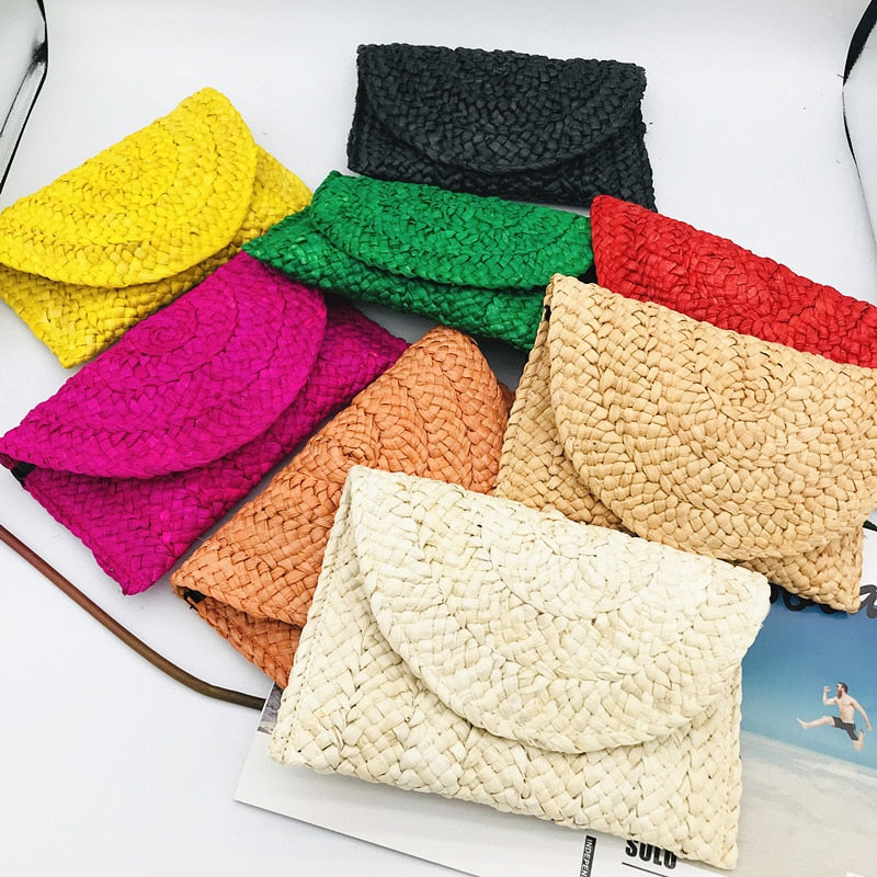 Small handmade woven straw clutch with a colorful pompom, offered in nine colors