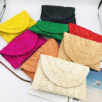 Small handmade woven straw clutch with a colorful pompom, offered in nine colors