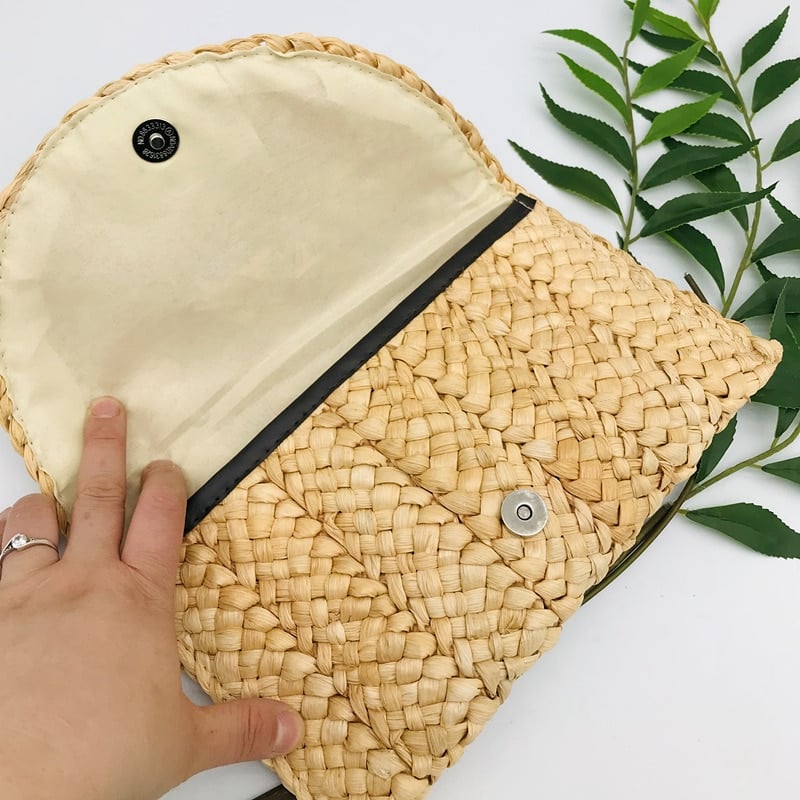 Small handmade woven straw clutch with a colorful pompom, offered in nine colors