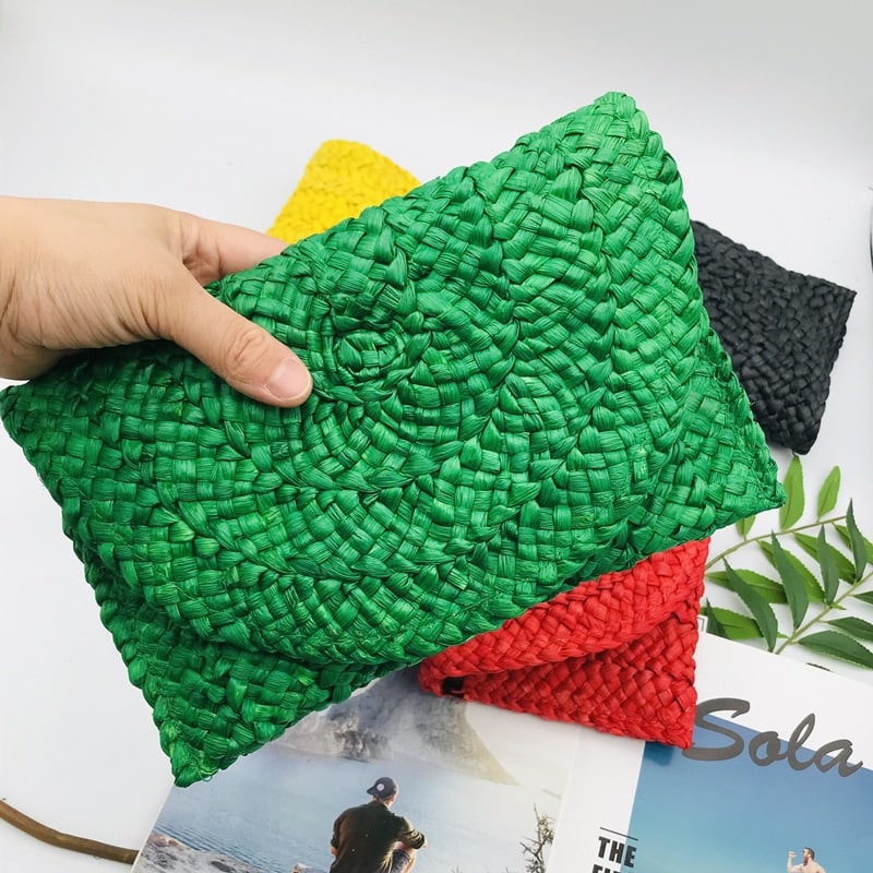 Small handmade woven straw clutch with a colorful pompom, offered in nine colors