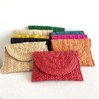 Small handmade woven straw clutch with a colorful pompom, offered in nine colors