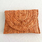 Small handmade woven straw clutch with a colorful pompom, offered in nine colors