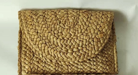 Small handmade woven straw clutch with a colorful pompom, offered in nine colors