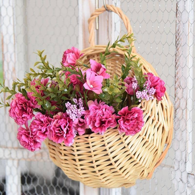 Two hanging rattan wall baskets filled with ivy
